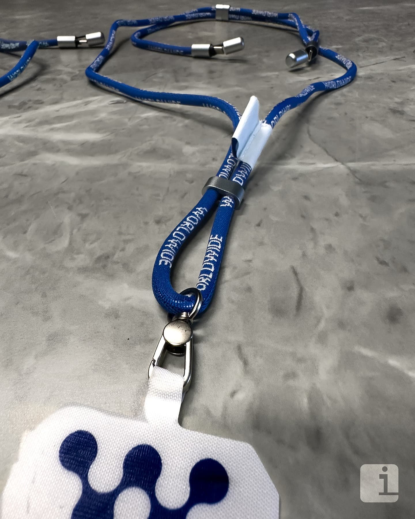 Lanyard portabadge personalizzati blu con stampa all-over e finiture metalliche, accessori brandizzati