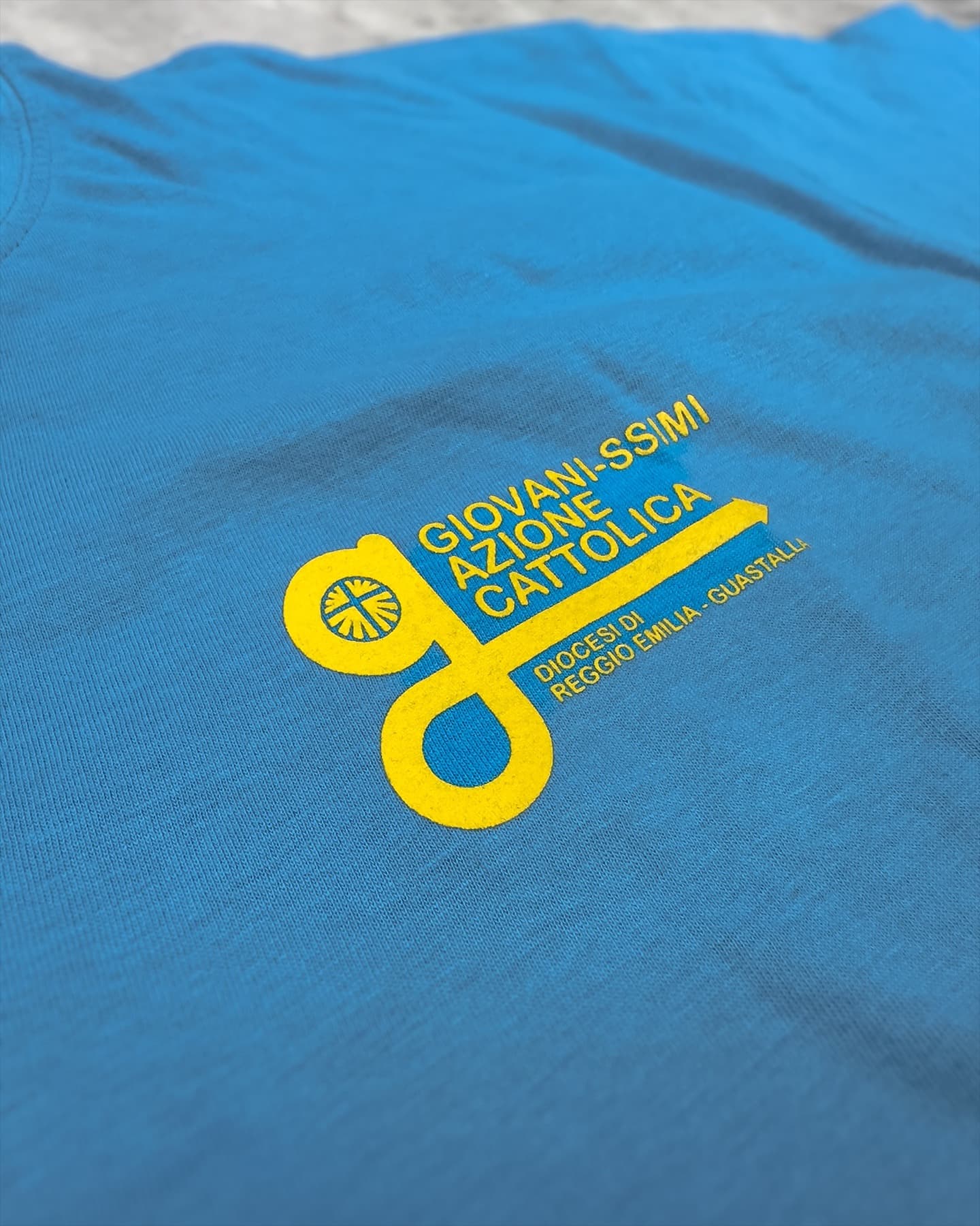 T-shirt azzurra personalizzata per Azione Cattolica con stampa serigrafica gialla, abbigliamento per associazioni