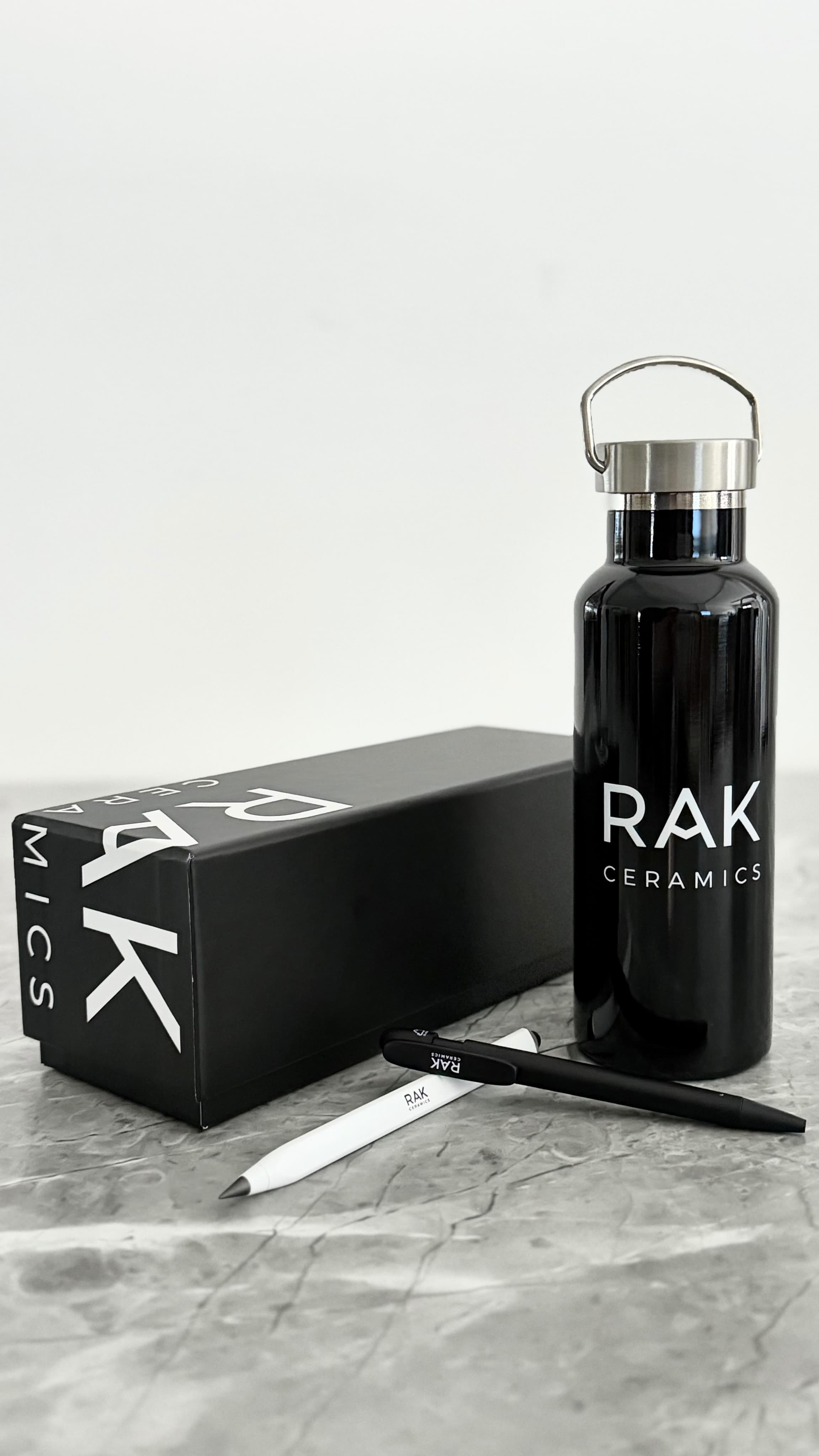 Borraccia termica nera personalizzata RAK Ceramics con penne brandizzate e packaging coordinato, prodotta con Imago et Inventum